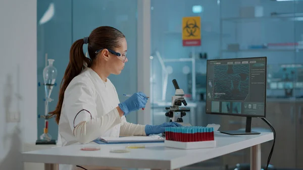 Scientific researcher looking at substance in test tube — Stock Photo, Image