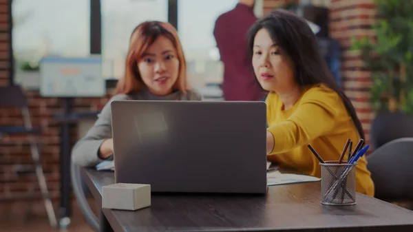 Mujeres asiáticas utilizando el ordenador portátil para investigar proyecto de negocio —  Fotos de Stock