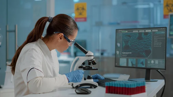 Science engineer using microscope to analyze dna sample — Stock Photo, Image