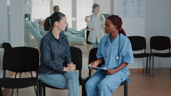 Kvinna som har samtal med sjuksköterska i väntrummet — Stockfoto