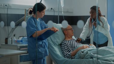 Hasta üzerinde steteskop kullanan Afrikalı Amerikalı bir cerrah.