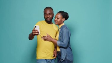 Mutlu insanlar stüdyoda selfie çekmek için cep telefonu kullanıyor.