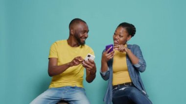 Erkek ve kadın stüdyoda birlikte eğlenmek için cep telefonu kullanıyor.