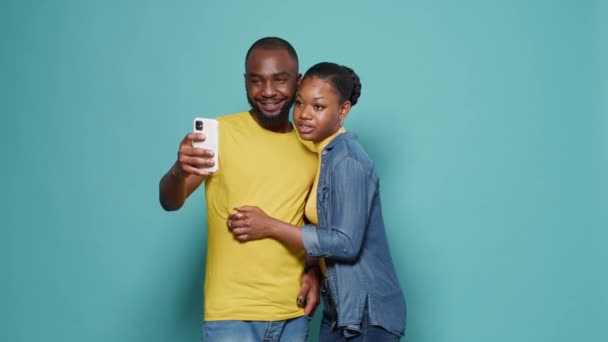 Cuplu care face selfie-uri cu smartphone-uri în fața camerei de studio — Videoclip de stoc