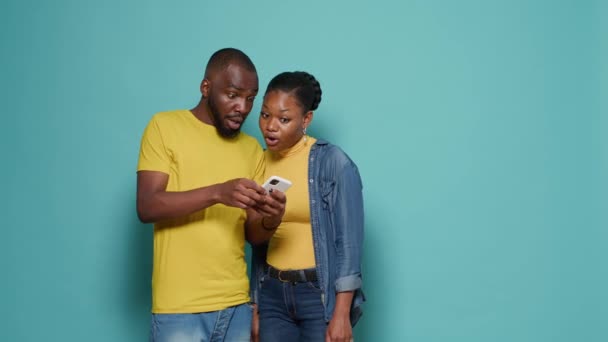 Uomo e donna che utilizzano internet su smartphone insieme davanti alla fotocamera — Video Stock