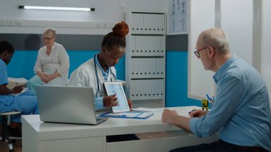 Tabletteki iskelet örneklerine bakan kıdemli hasta.