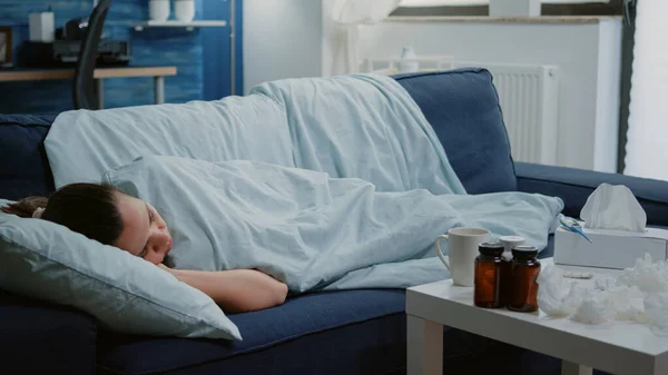 Nemocná žena ležící na gauči s dekou pocit chladu — Stock fotografie