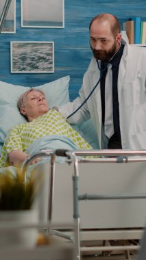 Hastalıklı yaşlı bir hasta tıbbi ekipten konsültasyon alıyor.