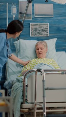 Hasta yaşlı kadın doktor ve hemşire tarafından ziyaret ediliyor.