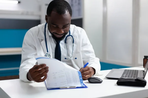 Africano terapeuta americano médico verificando documentos de prescrição de medicamentos — Fotografia de Stock