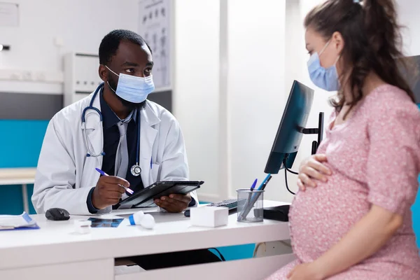 Sağlık kontrolünde doktorla olan hamile yetişkinler toplantısı. — Stok fotoğraf