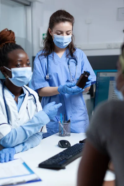 Ziekenhuis team discussiëren met Afrikaanse Amerikaanse zieke patiënt — Stockfoto