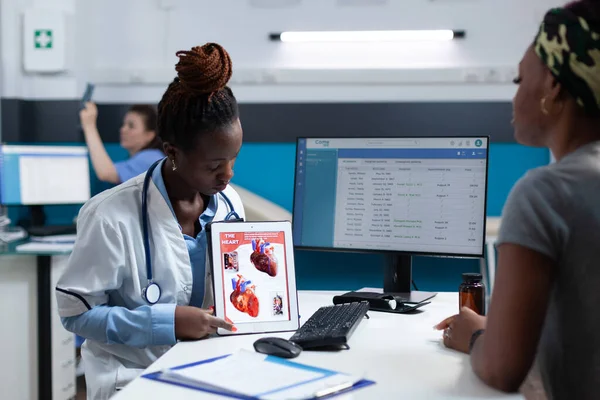 Médecin radiologue afro-américain tenant un comprimé expliquant la radiographie cardiaque — Photo
