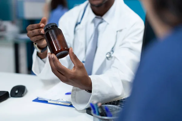 Closeup of african american pediatrician doctor holding pills bottle — Stock Photo, Image