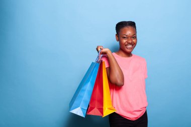 Afro-Amerikalı bir gencin portresi. Elinde alışveriş poşetleri var.