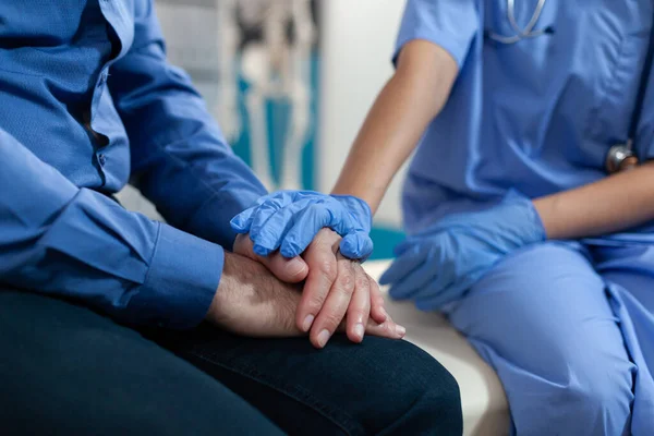 Primer plano de la enfermera cogida de la mano del paciente anciano para apoyo —  Fotos de Stock