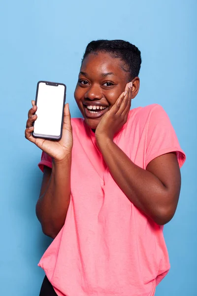 Retrato de adolescente afro-americano sorridente mostrando smartphone com display branco — Fotografia de Stock
