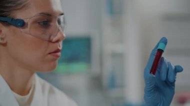 Test tüpündeki DNA analizi yapan bir mikrobiyolog.
