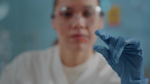 Woman biologist analyzing blood sample on glass tray — 图库视频影像