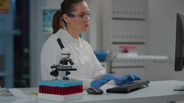Químico usando microscopio para estudiar sustancia de ADN en laboratorio — Vídeo de stock