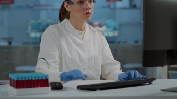 Porträt eines Chemikers mit Schutzbrille, der in die Kamera lächelt — Stockvideo
