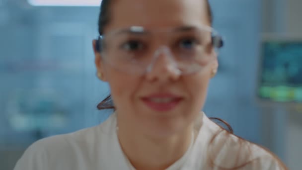 Біолог з захисними окулярами посміхається на камеру — стокове відео