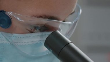 Kimyager optik araçta mikroskobik mercekten bakıyor