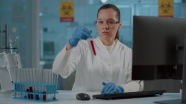 Kimya araştırmacısı test tüpündeki maddeye bakıyor.