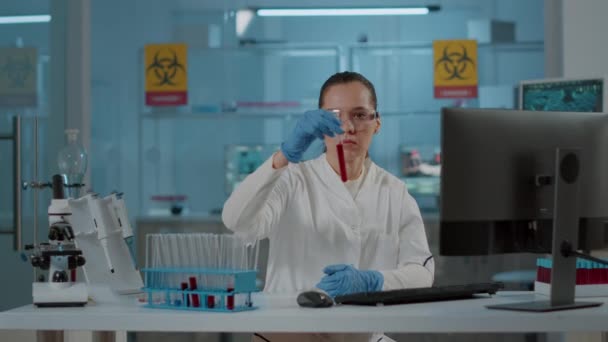 Wanita kimiawan menganalisis zat dalam tabung uji untuk ilmu pengetahuan — Stok Video