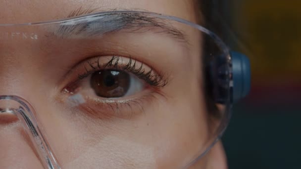 Жінка з захисними окулярами, що показують одне око перед камерою — стокове відео
