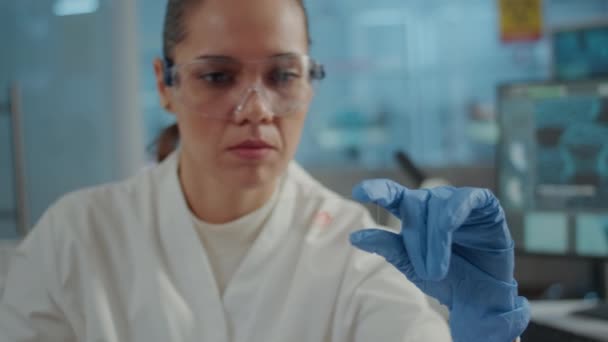Primer plano del biólogo analizando la muestra de sangre en cristalería de laboratorio — Vídeo de stock