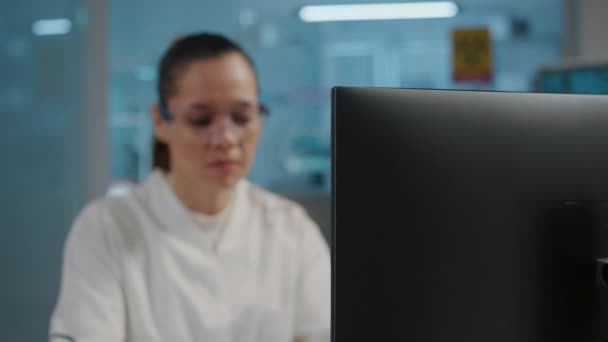 Bilim laboratuarında bilgisayar üzerinde çalışan kadın kimyager. — Stok video