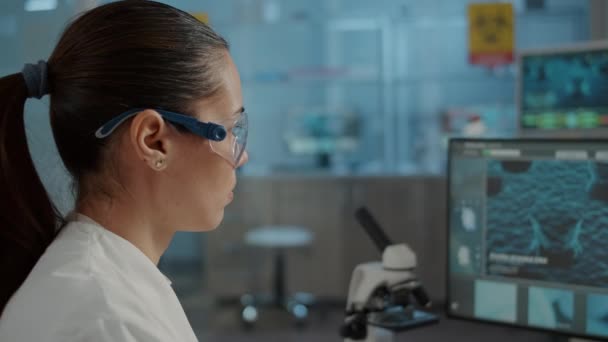 DNA animasyonunu incelemek için bilgisayarla çalışan bir biyoloji uzmanı. — Stok video