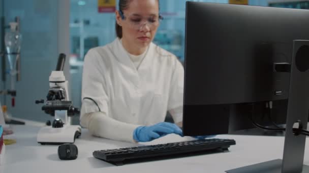 Especialista en gafas de seguridad con microscopio en laboratorio — Vídeo de stock