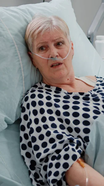 Nahaufnahme eines älteren Patienten, der im Bett liegt und mit einem Arzt spricht — Stockfoto