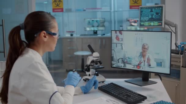Químico usando videollamada en línea en el laboratorio — Vídeos de Stock