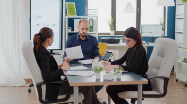 Proje için çizelge sunumunda takım çalışması yapan meslektaşlar