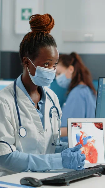 Médecin pointant vers la tablette avec organe cardiaque à l'écran — Photo
