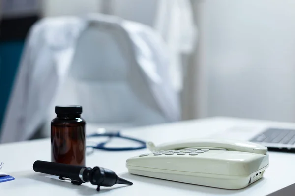 Крупный план медицинского отокопа и ландшафта, стоящих на столе в пустом кабинете врача — стоковое фото