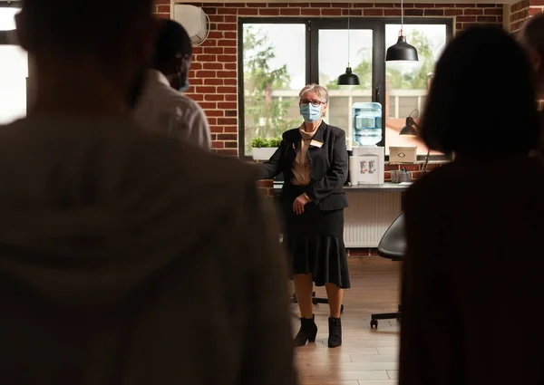 People at aa meeting standing in office to do mental health exercise with specialist — Stock Photo, Image