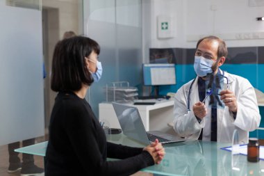 Ofisteki radyografi taramasına bakan uzman ve hasta.