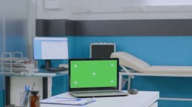 Boş hastane ofisi. Masasında tıbbi evraklar olan kimse yok.