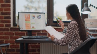 Dosyalarla mali evraklar üzerinde çalışan bir iş kadını