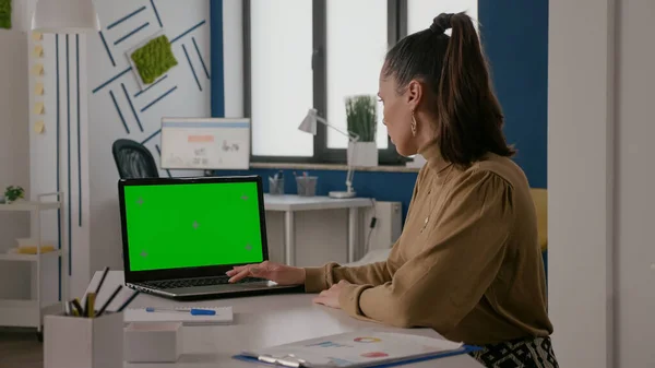 Masasında yeşil ekranlı bir kadın oturuyor. — Stok fotoğraf