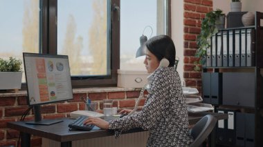 İş kadını ev telefonunda çalışıyor ve konuşuyor.