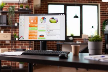 Boş işyerindeki masasında iş çizelgeleri olan bilgisayar