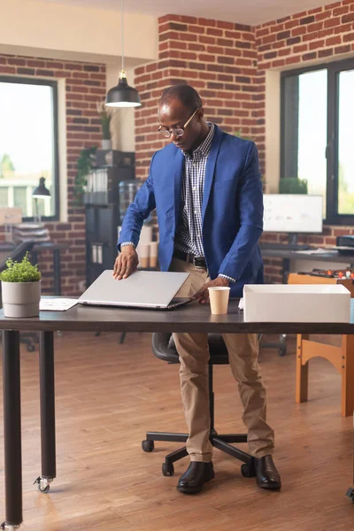 African american person gathering things in box after getting fired from business job — 图库照片