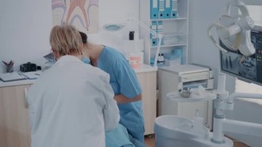 Diş hekimliği ekibi stomatoloji kabinesinde diş çıkarma işlemi yapıyor.