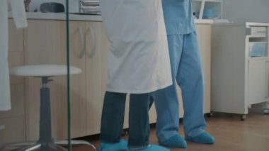 Kıdemli dişçi ve asistan takma diş röntgeni sonuçlarını inceliyor