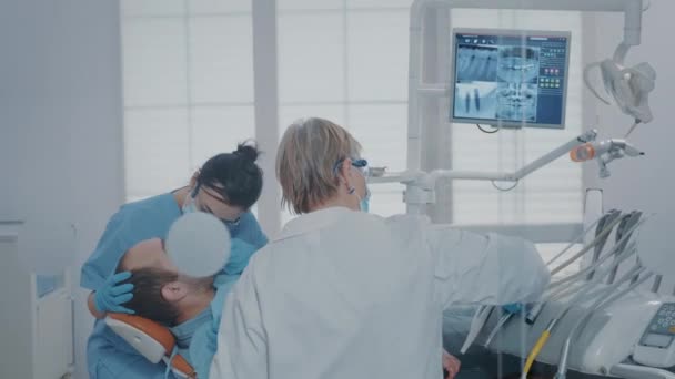 Медсестра та стоматолог використовують інструмент для видалення карієсу — стокове відео